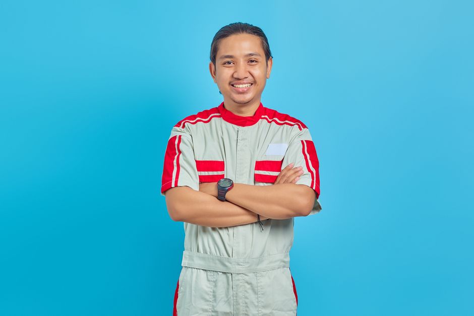 Smiling HVAC service technician holding tools